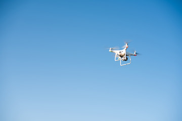White drone fly in the sky recording a video