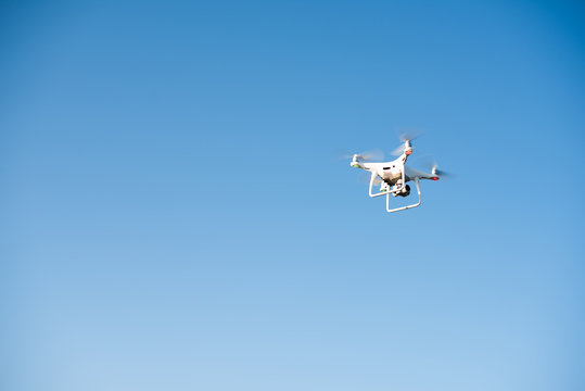 White drone fly in the sky recording a video