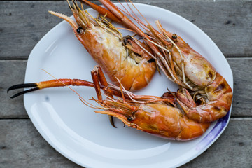 Closeup grilled shrimps on the white plate put on wood background in restaurant Ayutthaya, Thailand seafood 