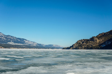 Fototapeta na wymiar early spring landscape of frozen Columbia Lake Regional District of East Kootenay Canada.