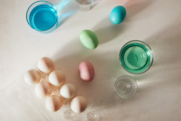 Easter eggs dyeing in glass with colors