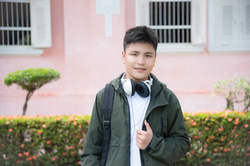Asian male teenager standing and smiles in park