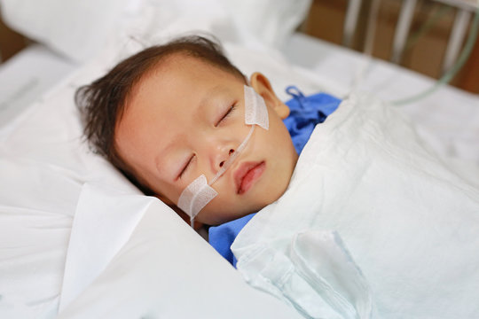Baby boy with breathing tube in nose receiving medical treatment. Intensive care at hospital.