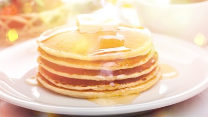 Stack of Small pancakes in syrup on background