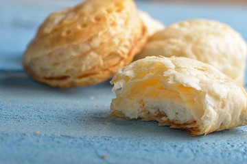 Mini cheese filled baked pies isolated on blue wooden background