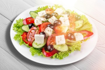 Greek salad with fresh vegetables on background