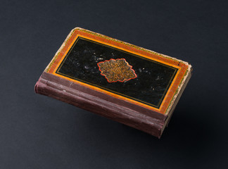 old shabby book on a black background. ancient handwritten book