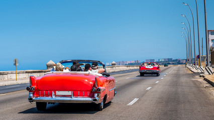 Havana Cuba. Old American cars runing along the malecon in la Habana.