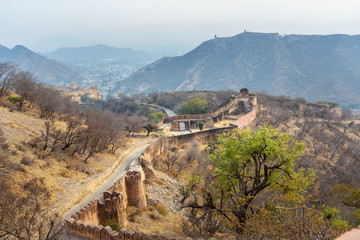 Fototapeta premium Ancient long wall with towers around Amber Fort. Rajasthan. India