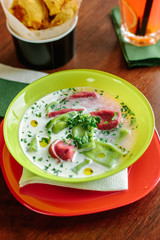 Green and red ravioli in soup for kids.