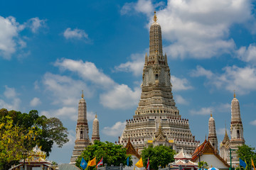 Wat Arun Ratchawararam with beautiful blue sky and white clouds. Wat Arun buddhist temple is the landmark in Bangkok, Thailand. Attraction art and ancient architecture in Bangkok, Thailand.