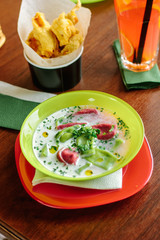 Green and red ravioli in soup for kids.