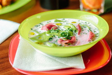 Green and red ravioli in soup for kids.