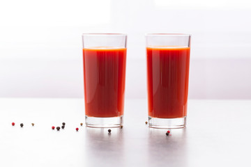 Fresh tomato juice with parsley and spices, selective focus. Glasses with tomato juice and fresh tomatoes on a table 
