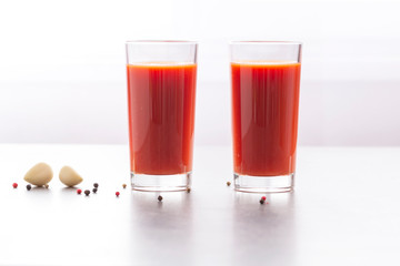 Fresh tomato juice with parsley and spices, selective focus. Glasses with tomato juice and fresh tomatoes on a table 
