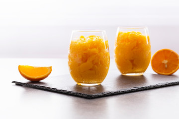 Fresh orange citrus sorbet garnished with mint - traditional cold dessert. Homemade fruit sorbet in a glass.