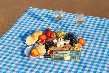 Summer Picnic on the beach at sunset. Rest with Wine at the sea. Food and drink concepts.