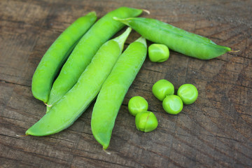 View of fresh ripe green peas lying on a rustic table. Peas in a pod close-up, organic food.