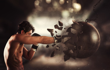 Power and determination of a young muscular boxer against a wrecking ball