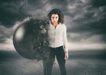 Power and determination of a young business woman against a wrecking ball