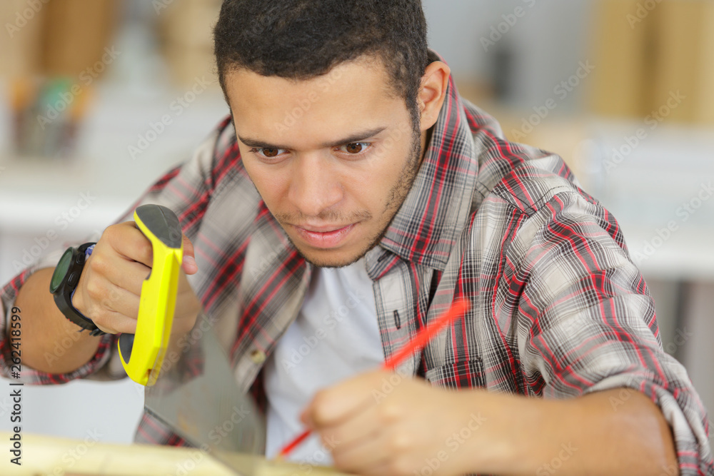 Wall mural young carpenter in workshop