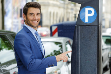 man paying car parking meter