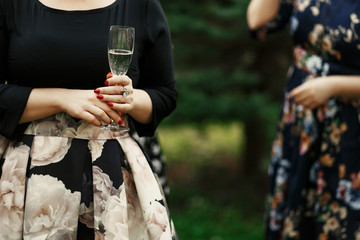 luxury stylish women at elegant celebration holding champagne in restaurant terrace