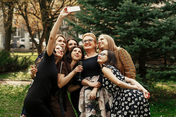 Fototapeta premium stylish elegant women taking funny selfie at celebration sunny in park, luxury happy life concept