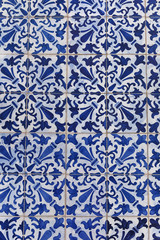 a fragment of the outer wall of a house in Lisbon decorated with ceramic tiles with a beautiful geometric pattern.