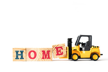 Toy forklift hold letter block e to complete word home on white background