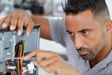 technician working on broken computer in workshop