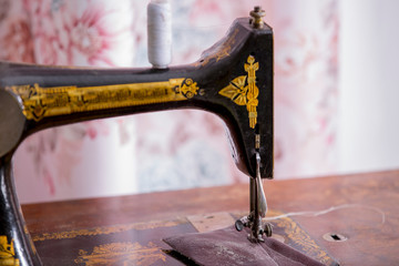 An old sewing machine sews fabric