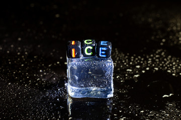 ice cubes reflection on black table background.
