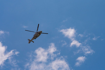 Fototapeta na wymiar Helicopter flying in the blue sky