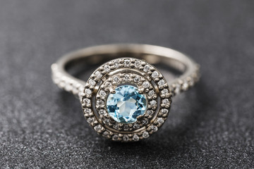 Gold ring with cubic zirconias and large topaz on a dark background, close-up