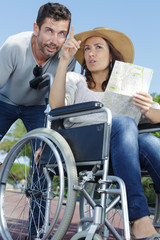 Plakat couple with map finding their way woman in wheelchair
