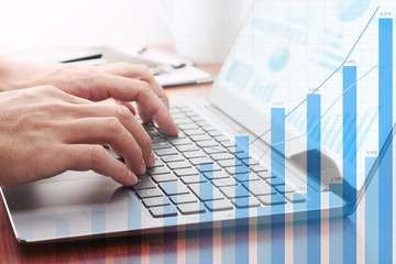 Business analysis concept. Businessman analyzing data and preparing reports.Laptop and growth...
