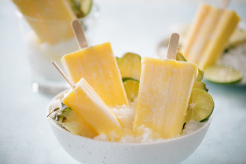 Some homemade Pineapple Popsicles (selective focus) on a rustic background