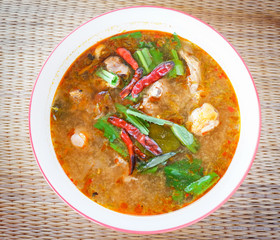Hot and spicy chicken soup bowl with herbs and spices thai style food