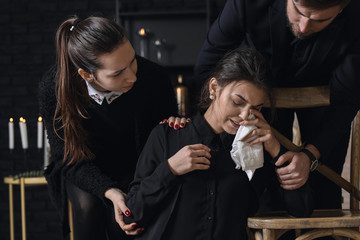 Relatives calming young widow at funeral