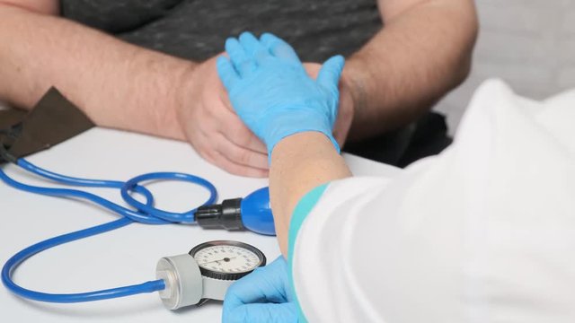 Woman doctor reassures patient by stroking his hands.