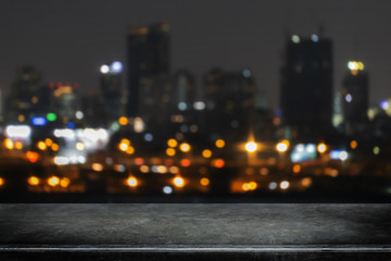 Empty black marble stone table top on abstract blurred nightclub party with cityscape building...
