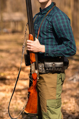 Autumn hunting season. Man hunter with a gun. Hunting in the woods