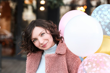 Naklejka premium Portrait of happy girl with air balloons outdoors