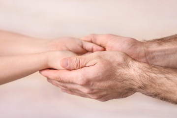 Hands of man and child on blurred background