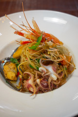 Spicy Seafood Spaghetti stir fried (Pad Cha) rolled in the fork on white dish of luxury restaurant