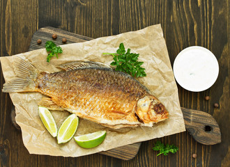 Fried carp with onions and white sauce.