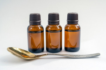 brown bottle of liquid and a spoon