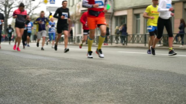 blurred marathon runners on streets of city in early spring
