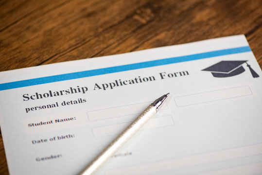 Scholarship application form document contract concept with pen for grants education on wooden table
